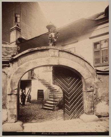 Quelle: Wien Museum, Inv.Nr. 27207/2, Foto: A. Stauda

Zum heiligen Florian (2, Floßgasse [ursprünglich Florianigasse] 7), Schild eines Hauses in der Leopoldstadt, in welchem sich das Wirtshaus "Zum guten Hirten" befand. Das Wirtsgeschäft betrieb 1803-1808 und 1812-1816 der bürgerliche Bierwirt Franz Strauß, dessen hier am 14. März 1804 geborener Sohn Johann Baptist als Johann Strauss (Vater) berühmt werden sollte. An dem später umgebauten Haus wurde am 4. Oktober 1883 eine von Wiener Bürgern gestiftete Gedenktafel enthüllt; die Festrede hielt der Schauspieler Karl Blasel. 1906 wurde ein Neubau errichtet (Gedenktafel auf diesen übertragen). 